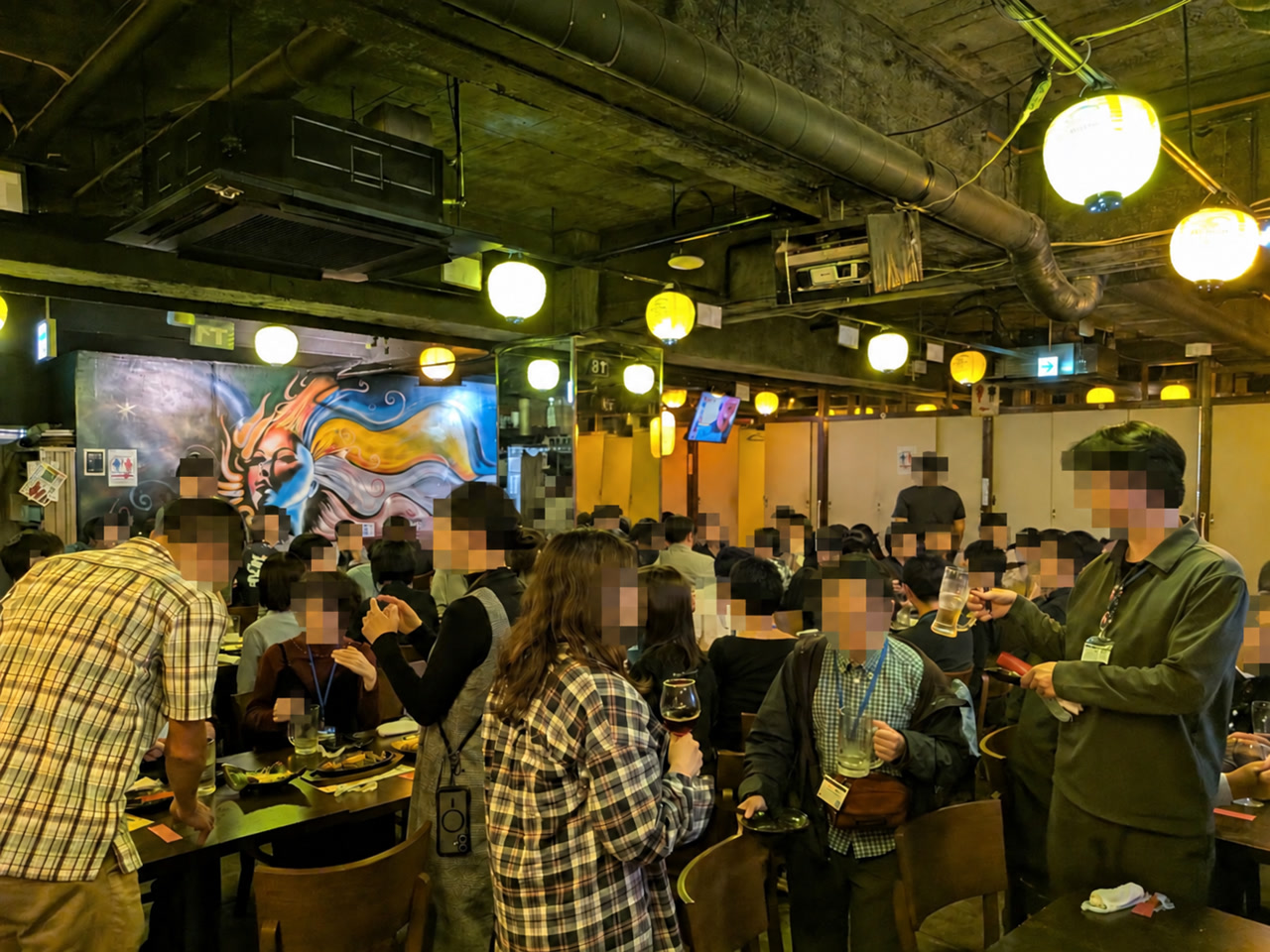 懇親会で料理や飲み物の並ぶテーブルを囲む参加者